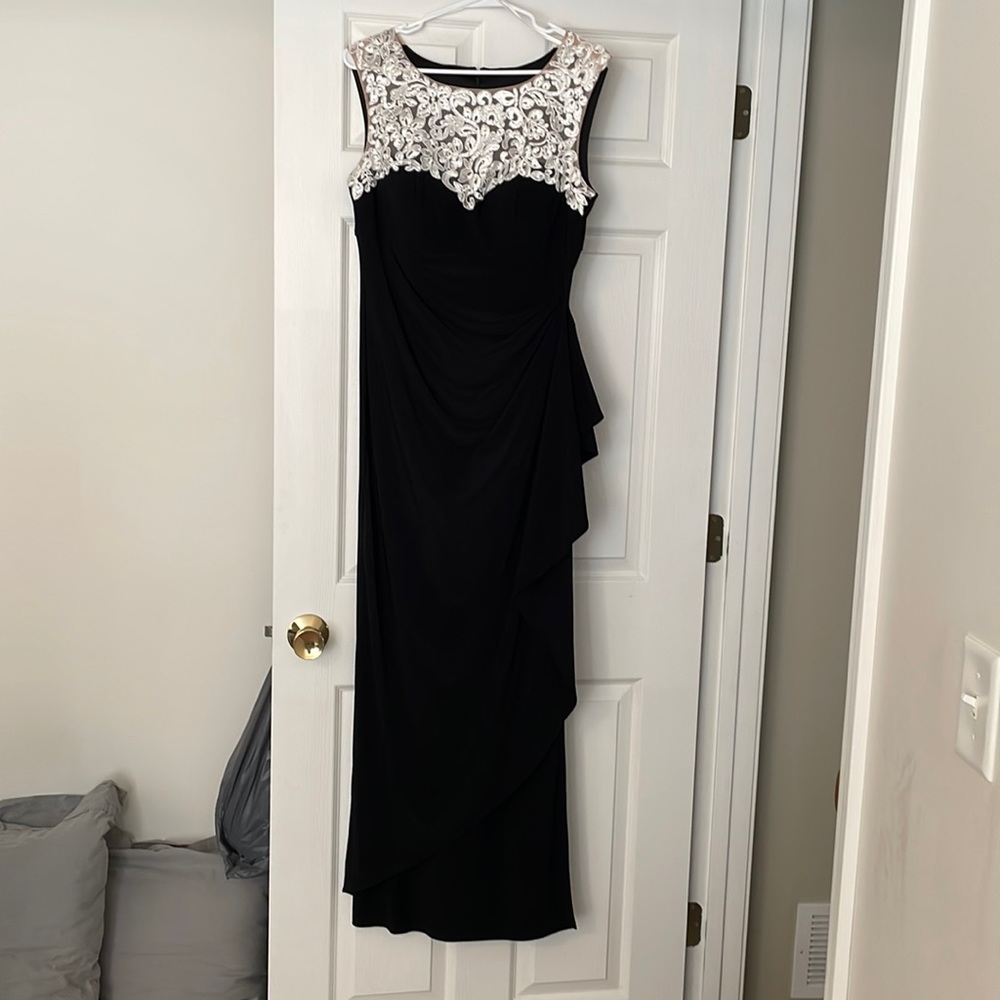 Formal black dress with white lace detail on nude sheer material.
